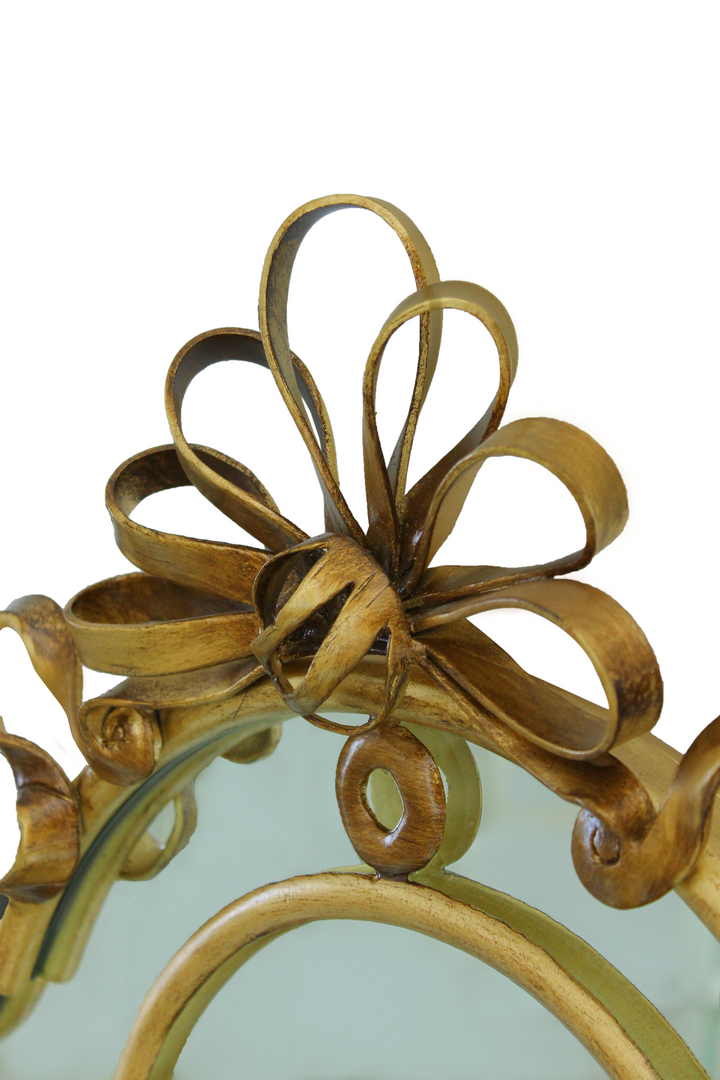 A captivating close-up of the Harmony Mirror, showcasing its intricate details, antique finish, and delicate ribbon accent for a touch of refined elegance
