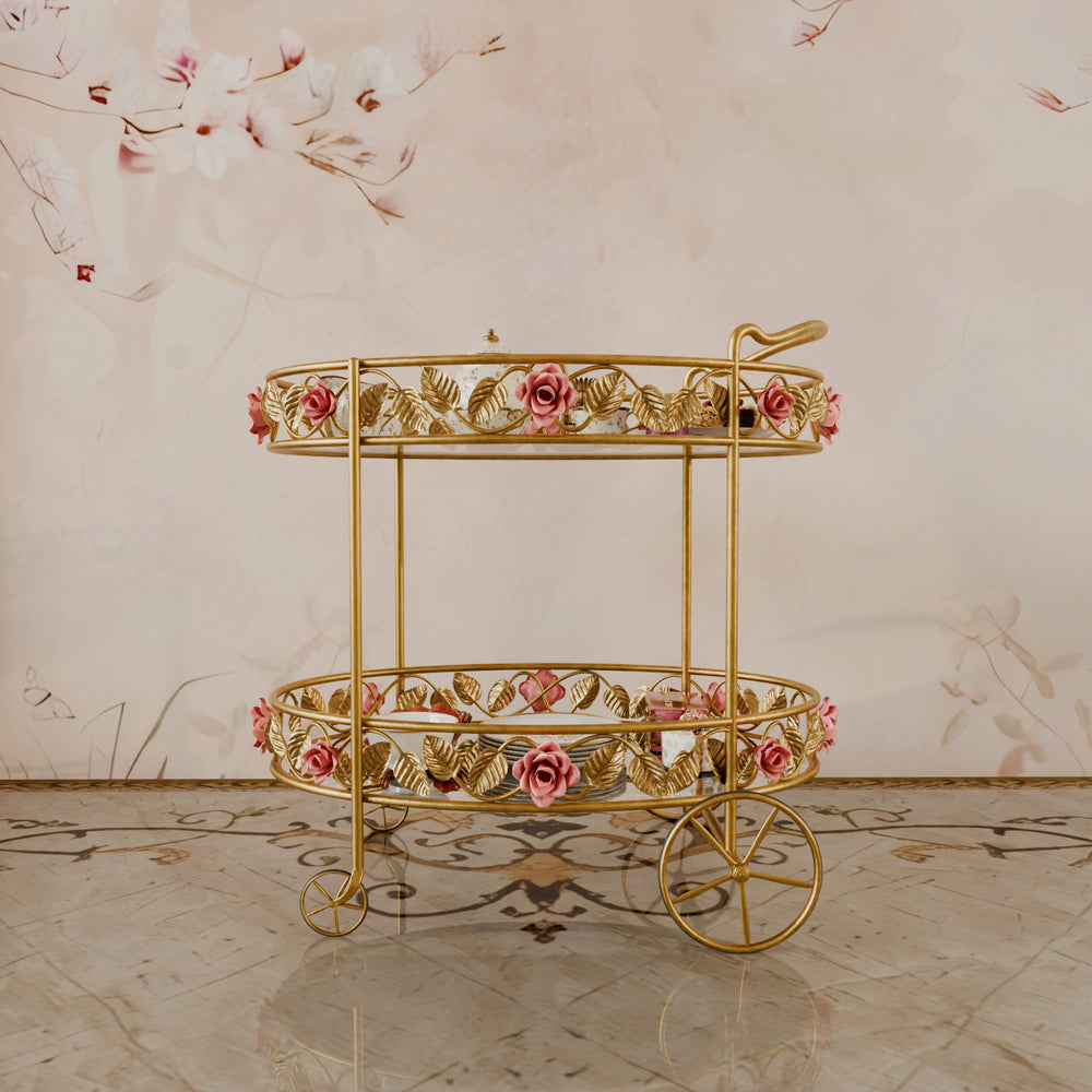 Opulent two-tier gold serving trolley with romantic floral motifs and delicate pink rose embellishments, styled in a sophisticated setting