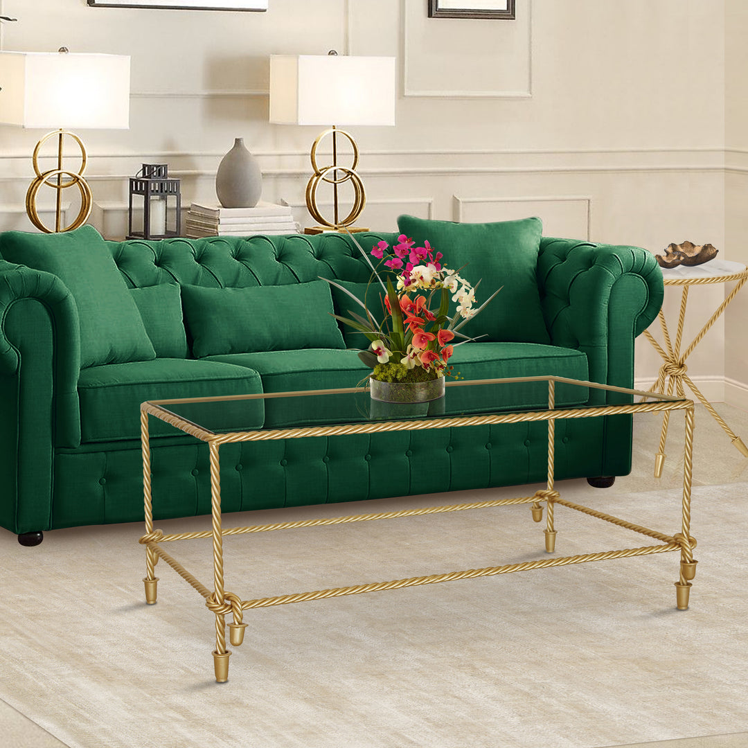 Rope themed steel table of rectangular shape and golden color with clear glass top in a classical living room