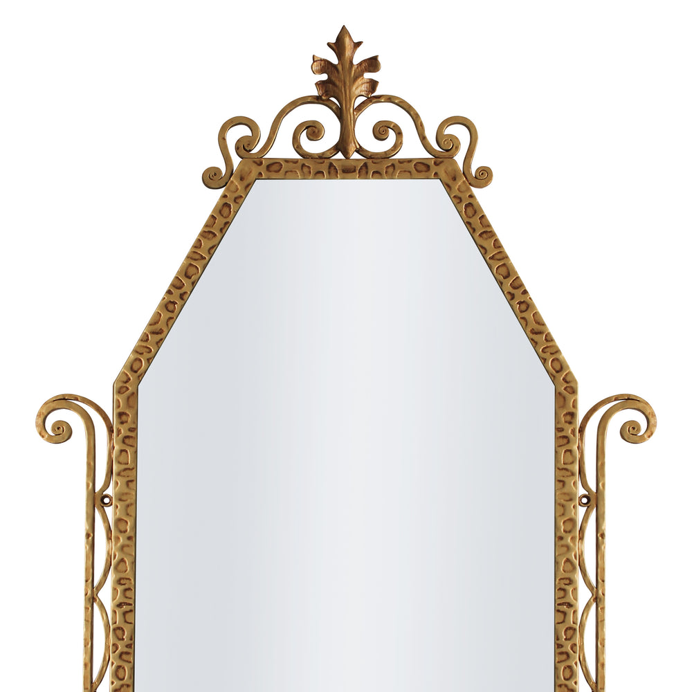 A close up of a classical hand forged mirror with textured scrolls painted in an antique gold finish