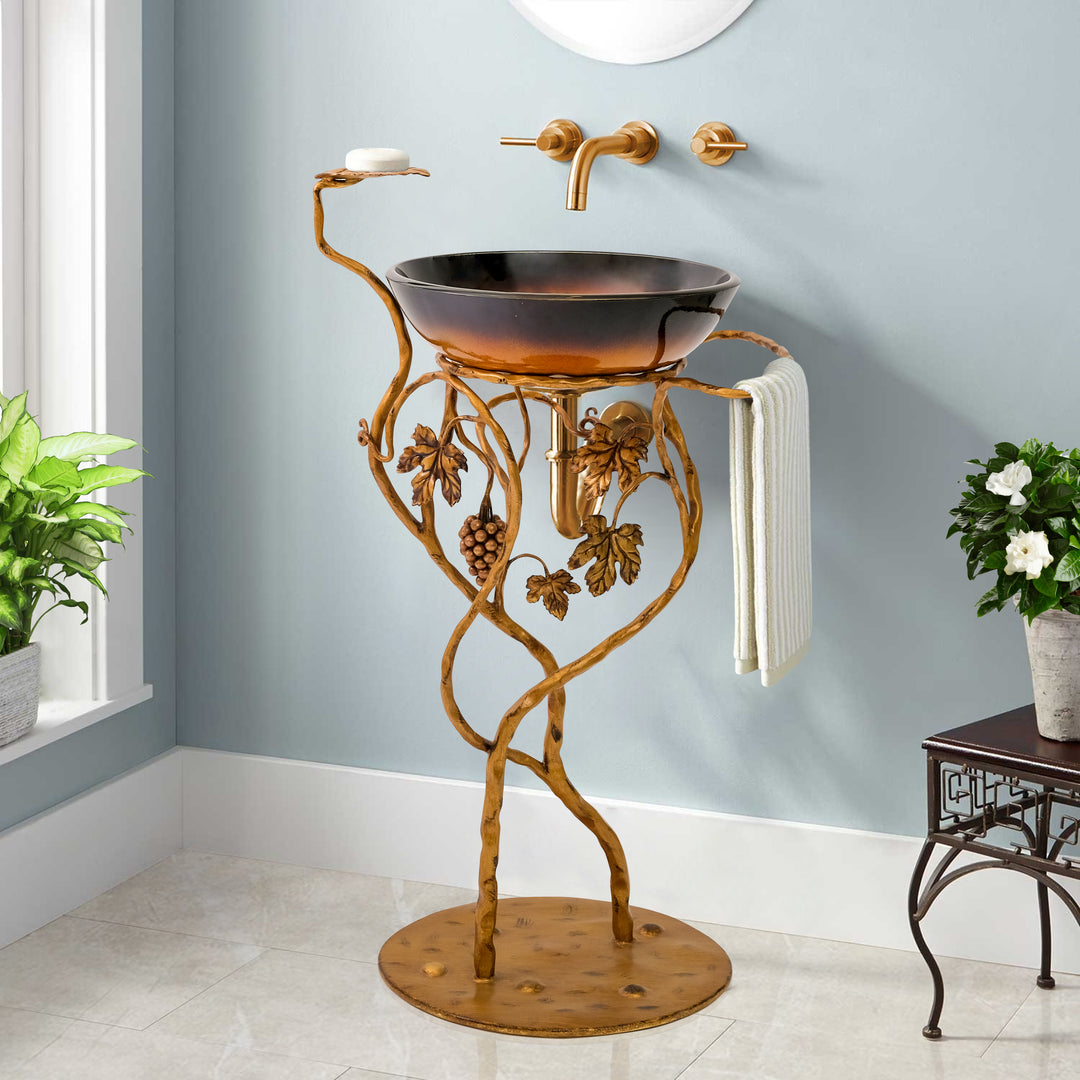 A decorative metal wash basin stand with base inspired by grapes and vines, painted in an antique golden finish