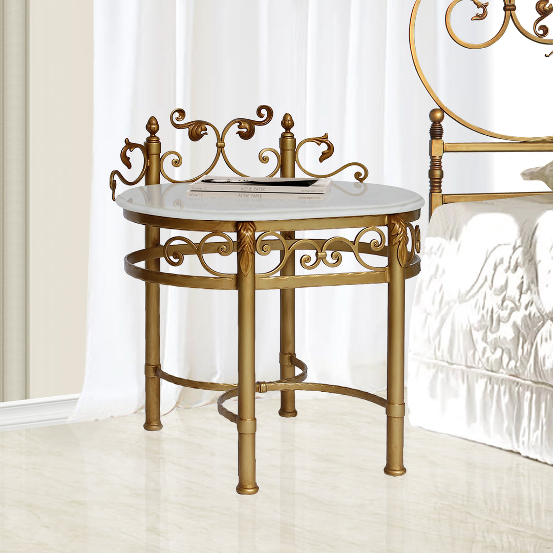 Ornate nightstand with curved gold base and marble top beside a classic bed