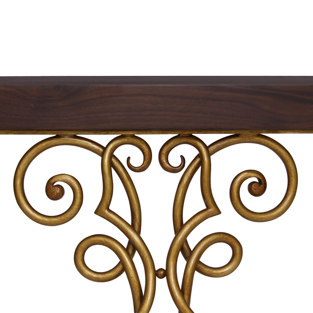 Close up of a bronze colored classical console with a wrought iron base made up of scrolls and a wooden top