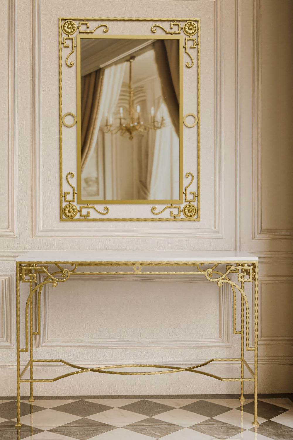 Gold iron forged console table and mirror in a room with a chandelier reflection
