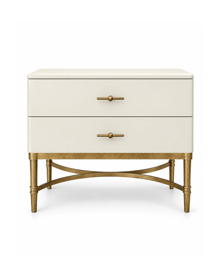 Michele Nightstand in ivory with two spacious drawers, antique brass bar handles, tapered antique brass legs, and elegant curved cross-stretcher detailing on a clean white background.