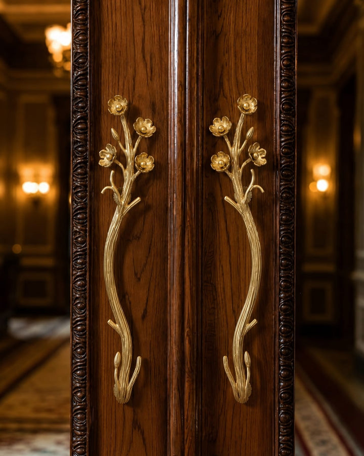 Close-up of ornate dark decorative gold-toned branch-shaped handles on antique wooden door