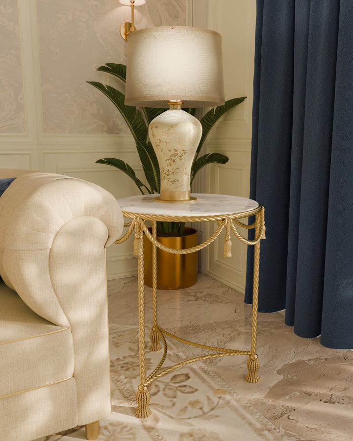 Allegra round side table in gold with marble top, showcasing sculptural rope detailing in a refined interior setting.