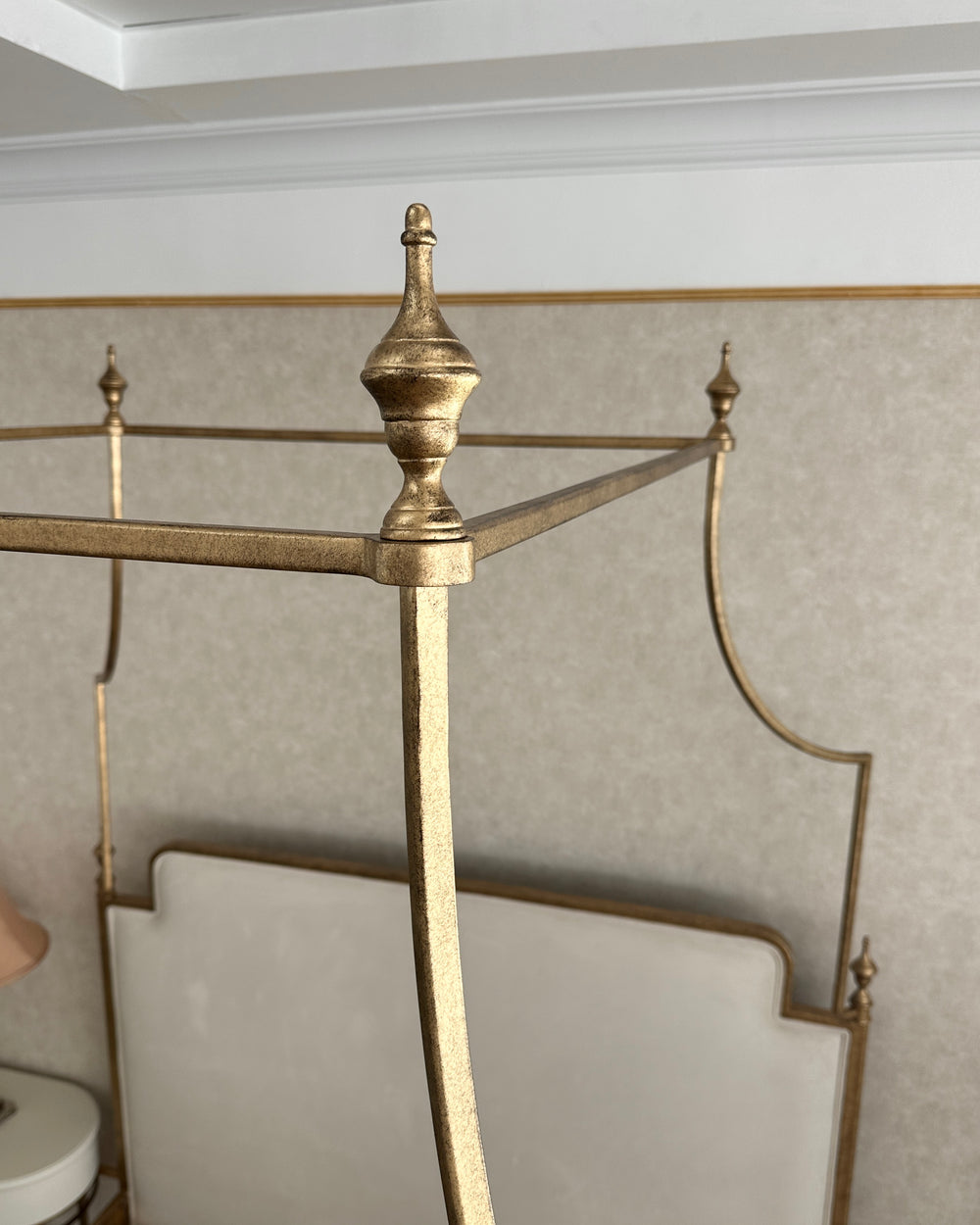 Close-up of Ella canopy bed upholstered headboard and refined metal detailing