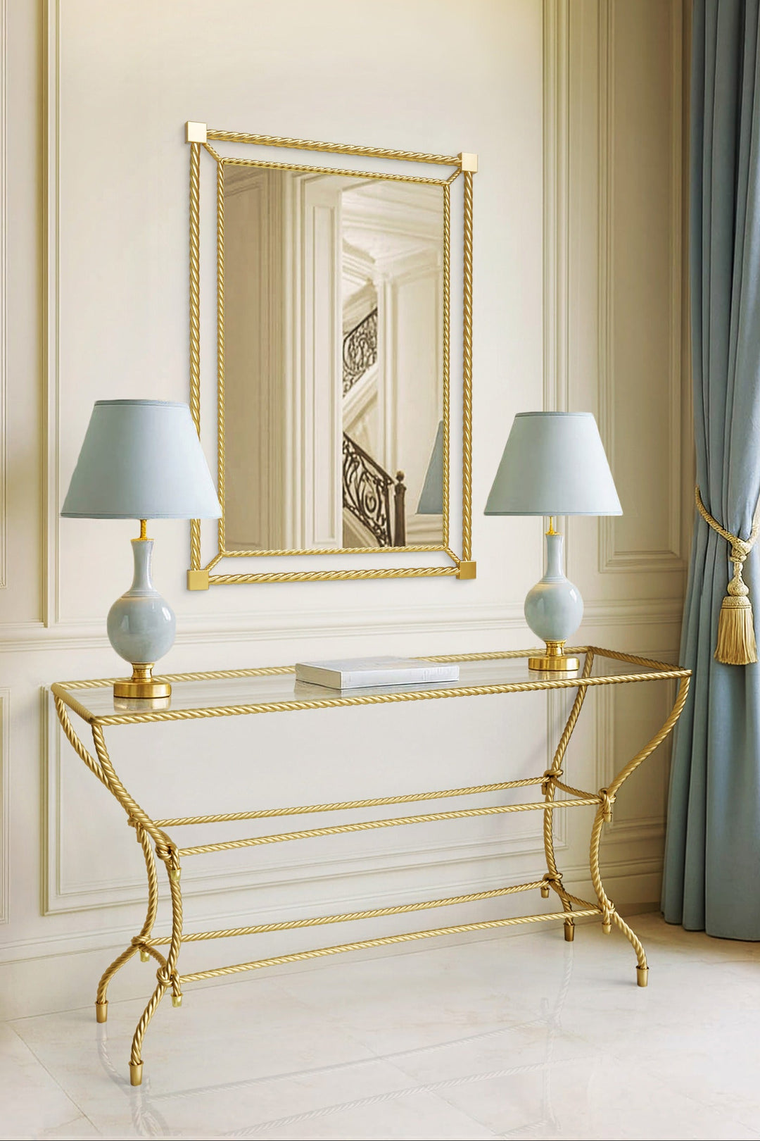 Noura console table in antique gold with rope-inspired metalwork, styled beneath matching mirror in an elegant classical interior.