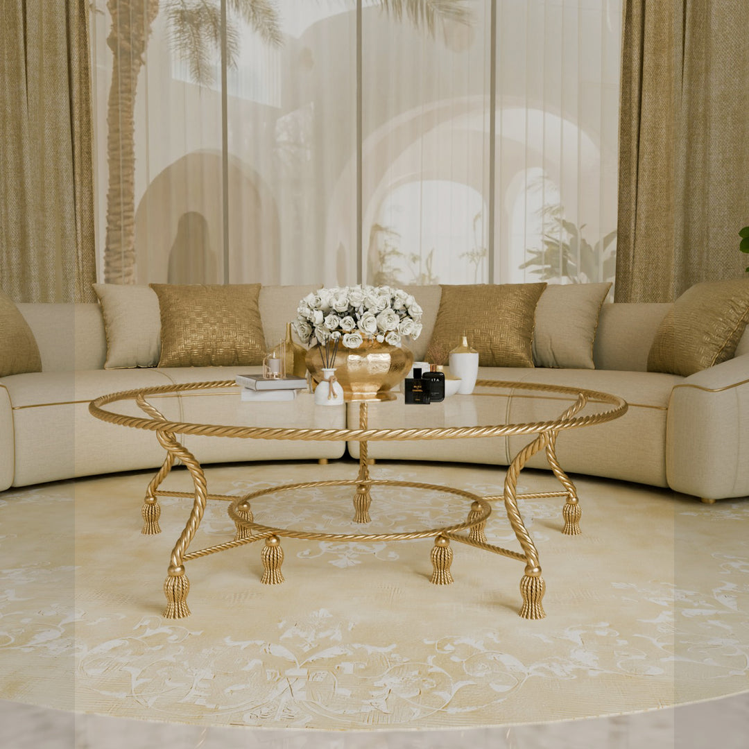 Elegant round gold center table with glass top in a luxury beige majlis setting