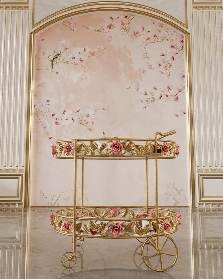 Front view of the Juliet serving trolley in gold, featuring hand-forged pink roses, leaf motifs, with glass and mirror shelves