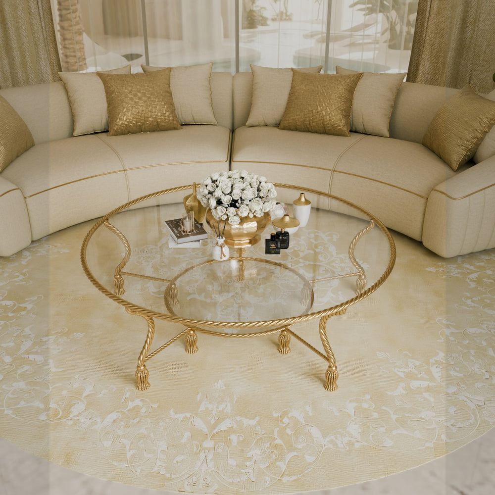 Overhead view of round glass coffee table with gold tassel legs in a majlis