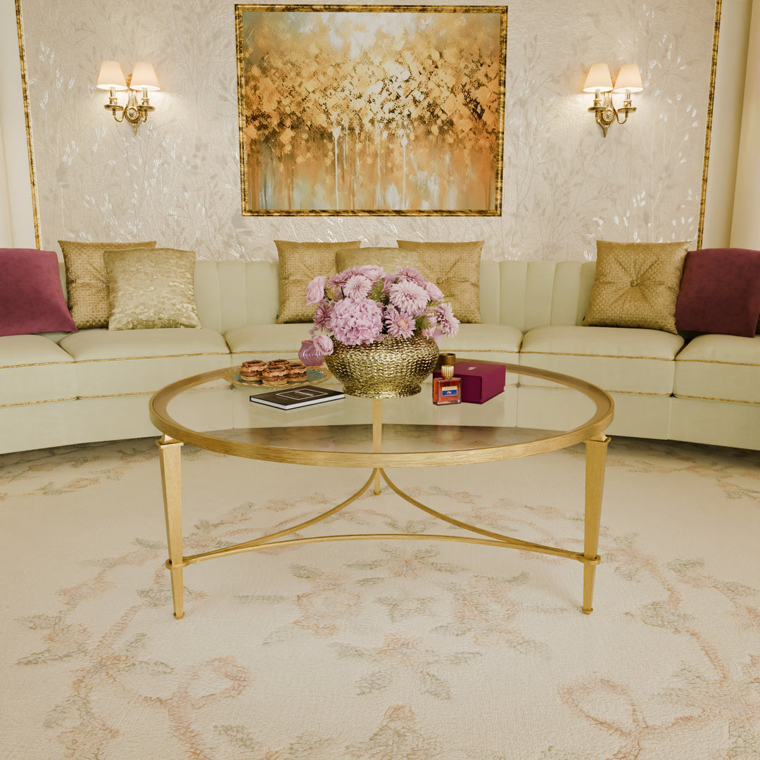 Luxury round gold and glass coffee table with slender legs — Victoria Table by Choufani, styled in elegant majlis interior.