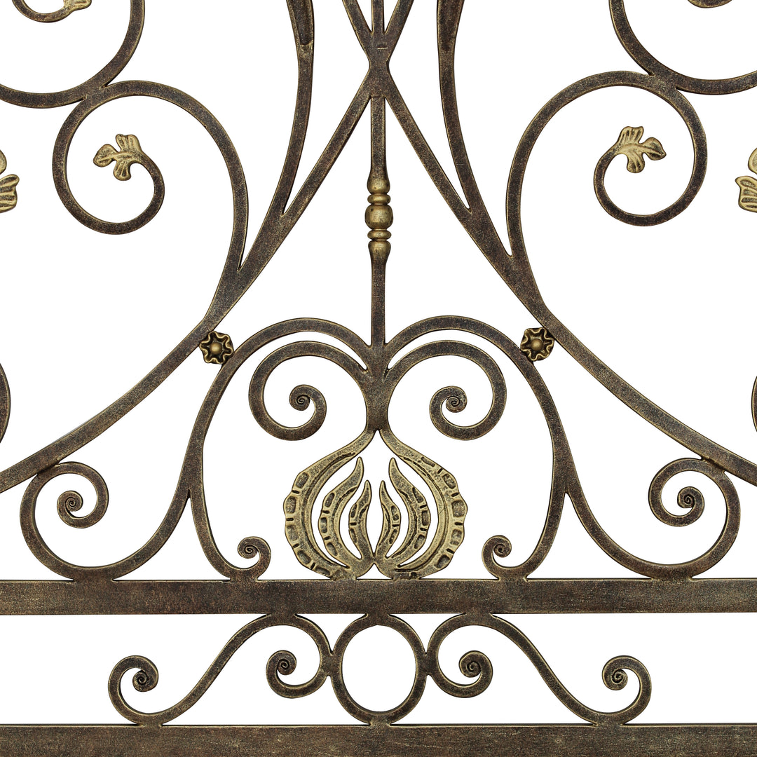 Close up of an Art Nouveau inspired metal headboard made up of scrolls and leaves, painted in an antique bronze finish