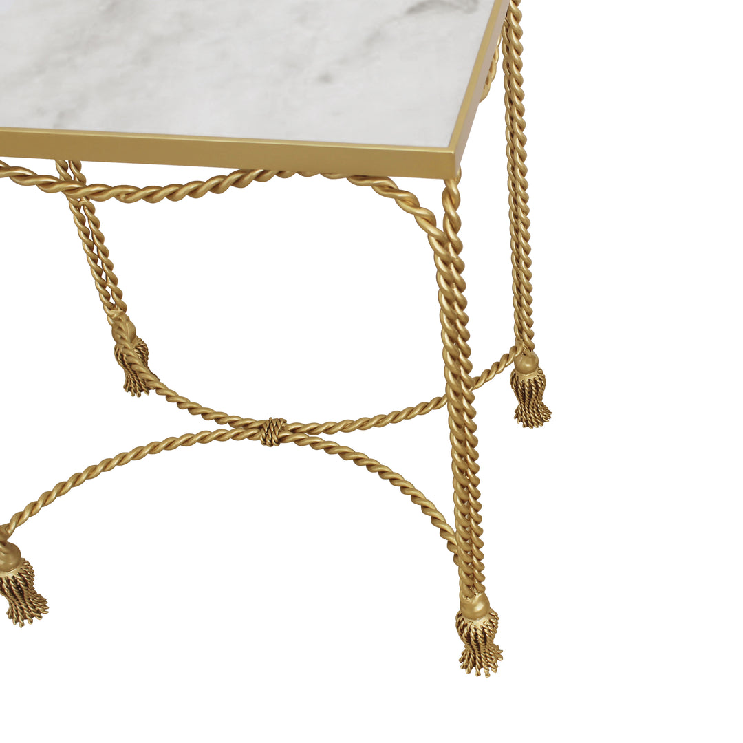 A combination of twisted metal rope and small metal tassels make up a unique accent table topped with a natural marble