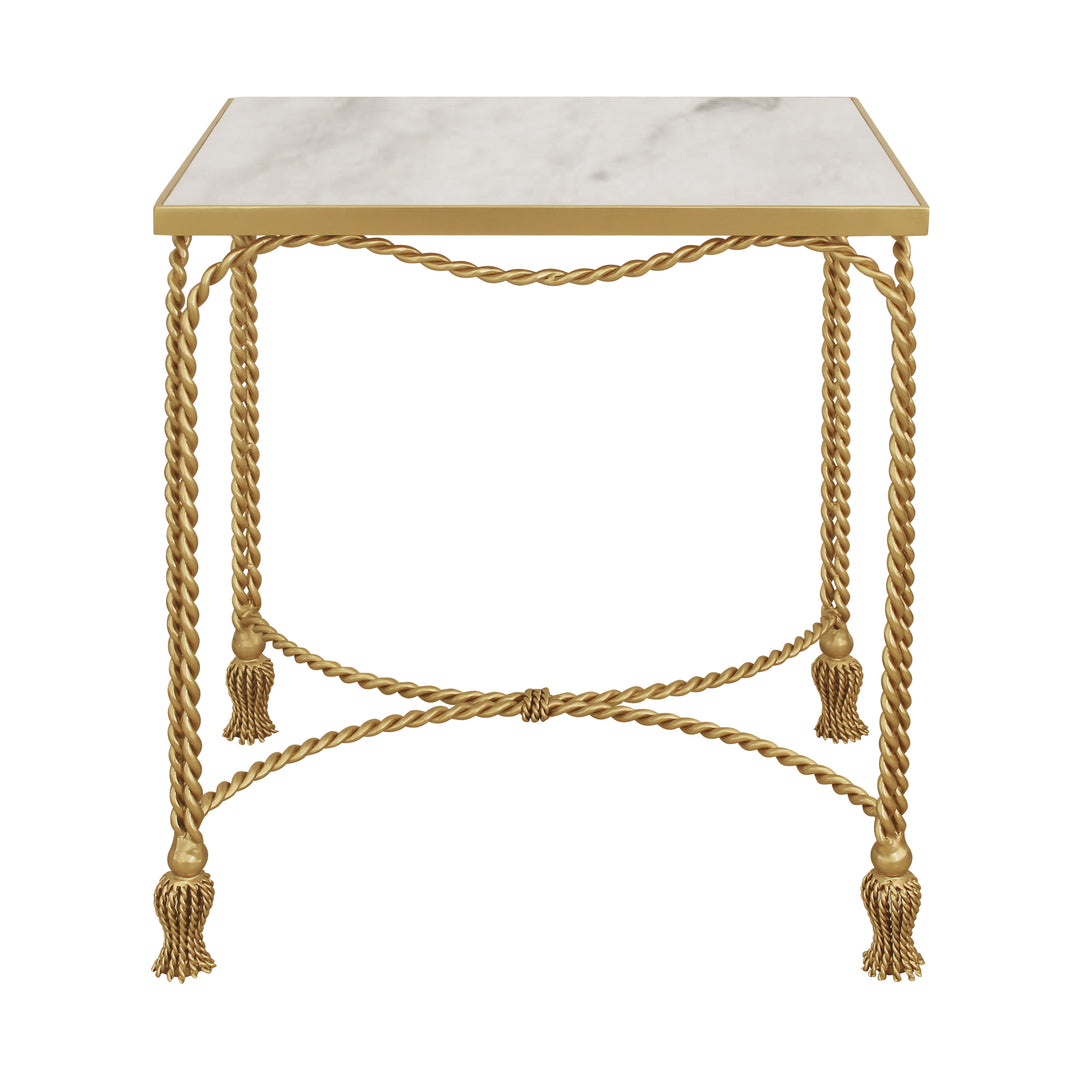 Wavy golden metal ropes and golden tassel feet make up the base of a luxury end table topped with a rectangular piece of natural marble