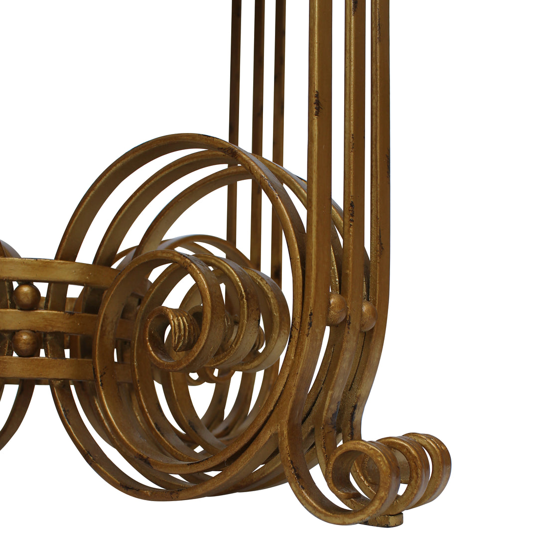 A detailed shot of a luxury table showing several layers of wrought iron scrolls in an antique gold finish