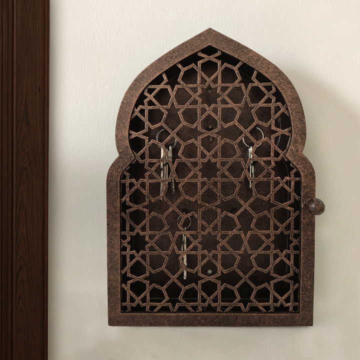 A wall mounted bronze decorative key cabinet with an Islamic design pattern 