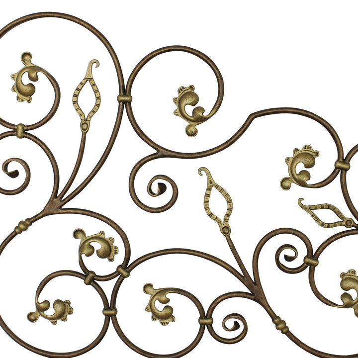 Close up of a classical wrought iron headboard made up of scrolls and leaves, painted in an antique bronze finish