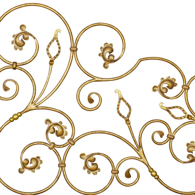 Close up of a classical wrought iron headboard made up of scrolls and leaves, painted in an antique golden finish