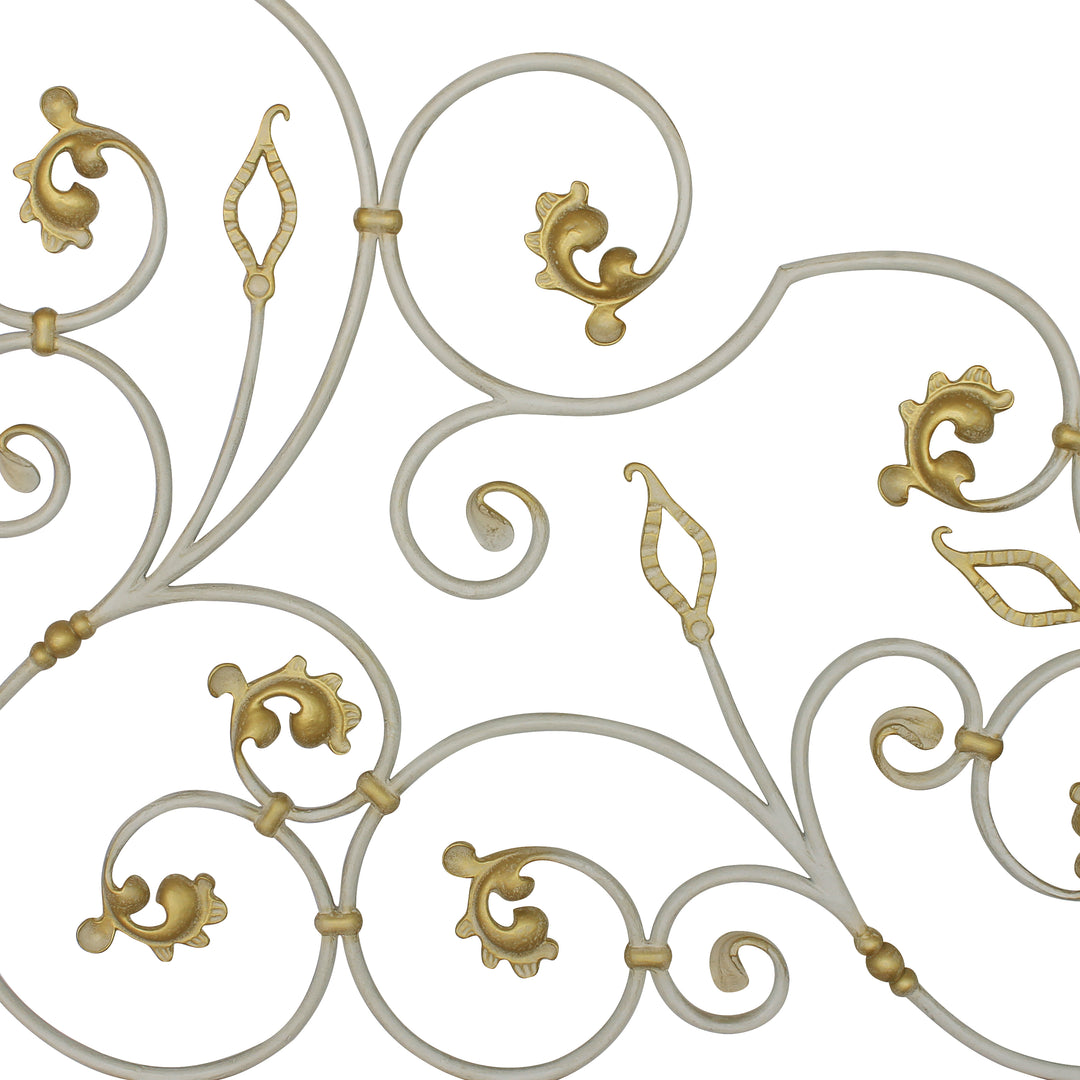 Close up of a classical wrought iron headboard made up of scrolls and leaves, painted in an antique white finish