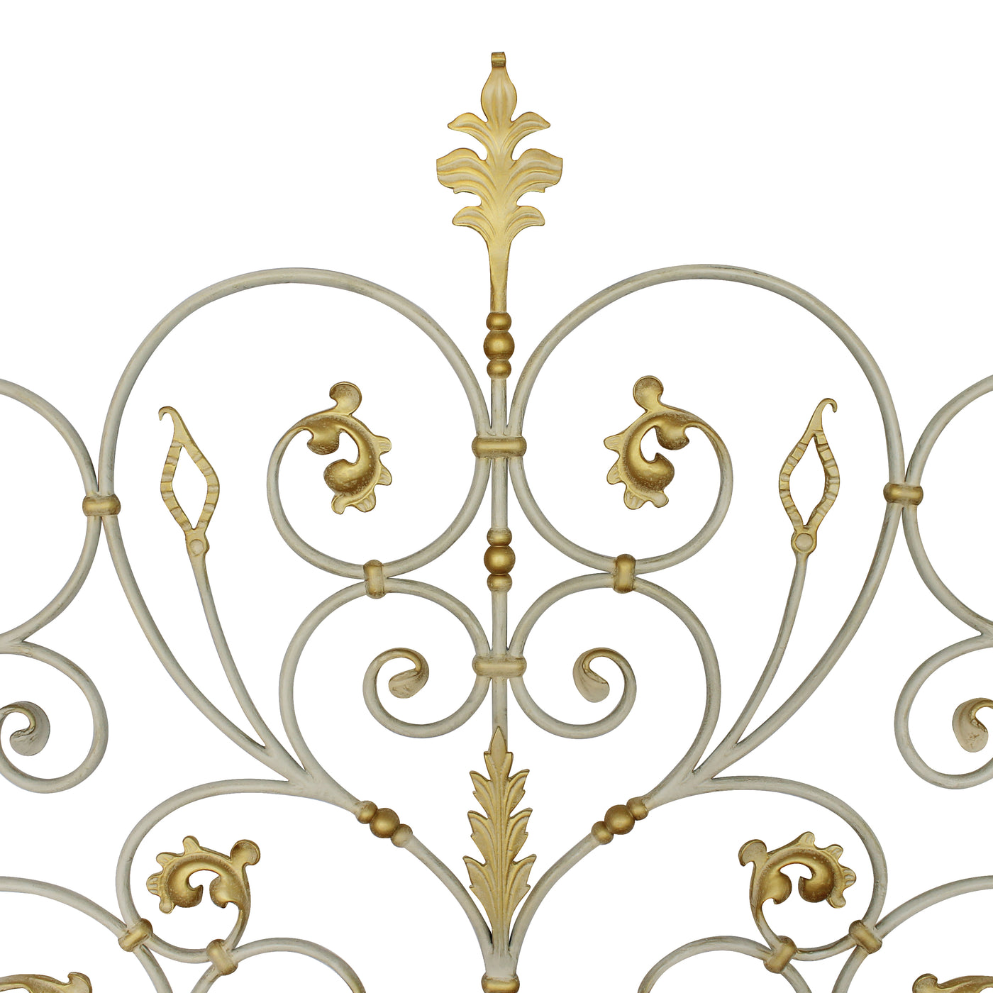Close up of a classic metal headboard made up of scrolls and leaves, painted in an antique white finish