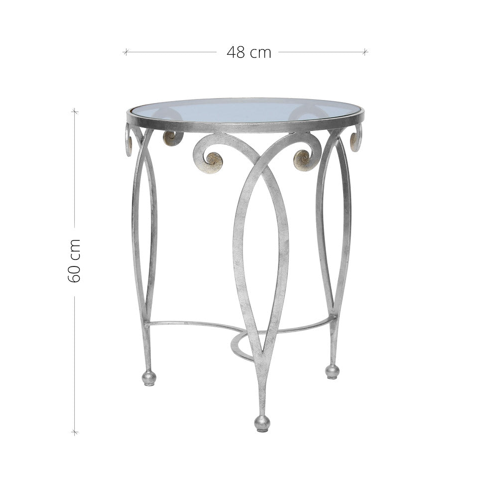 An exquisite silver end table made of metal scrolls topped with a clear round glass