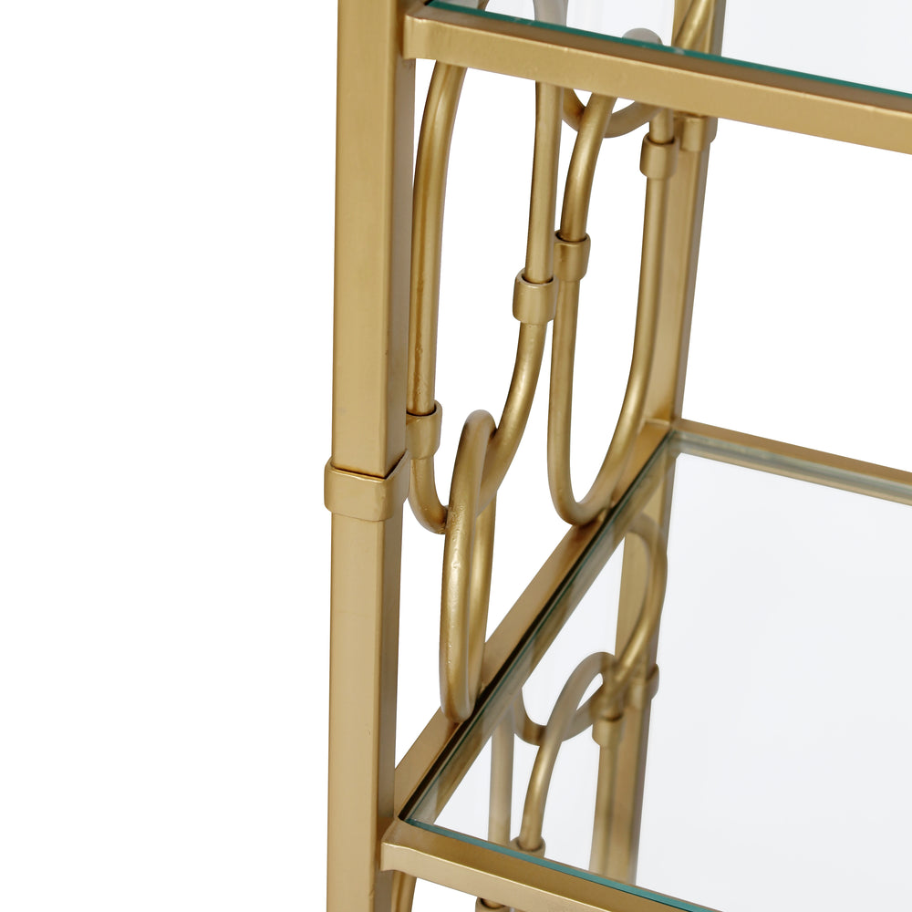 Close up of a decorative gold metal bookcase with glass shelves