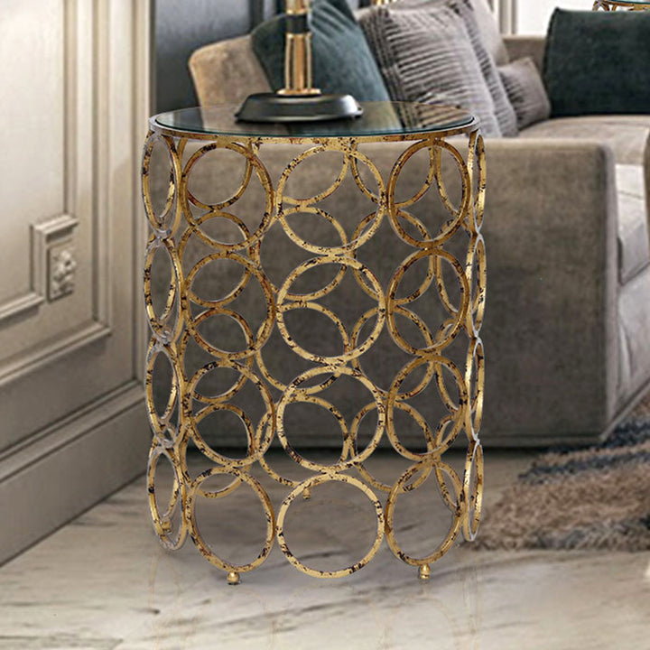 A trendy round side table made of forty golden rings with a clear glass top