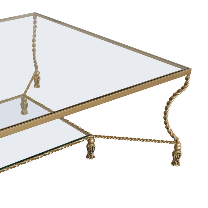 Detailed shot of a golden modern coffee table with two layers of glass inspired by twisted rope