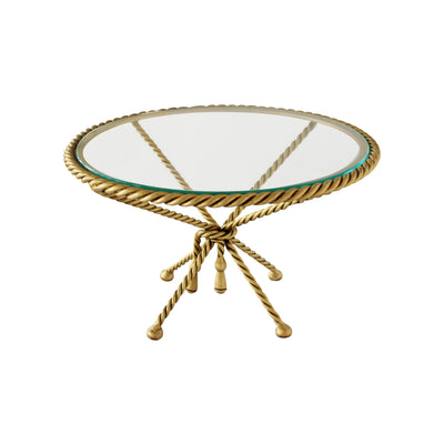 A golden cake stand with a rope-inspired design topped with a clear round glass