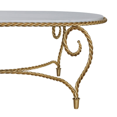 Detail of golden coffee table inspired by twisted rope, topped with natural marble