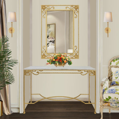A classical golden wrought iron mirror and console sit in a niche in a luxurious living space