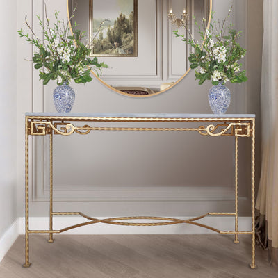 Decorative golden metal console table topped with white marble and two blue flower vases on top