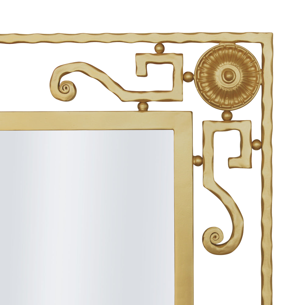Close up shot of a classical mirror with wrought iron scrolls and motifs in a gold painted finish