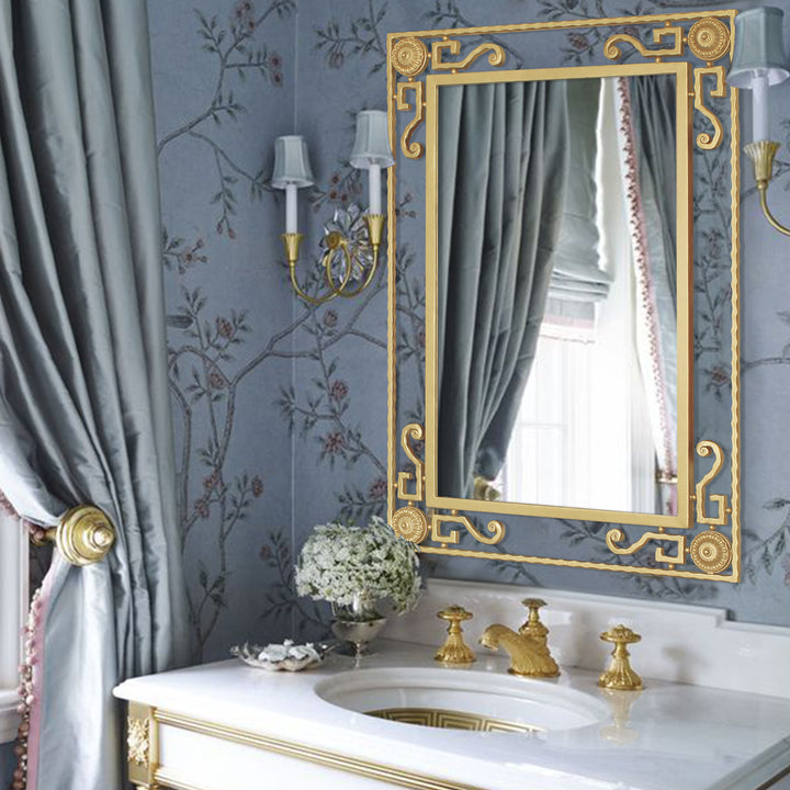 A classical golden rectangular mirror sits above a bathroom sink in a luxurious blue washroom