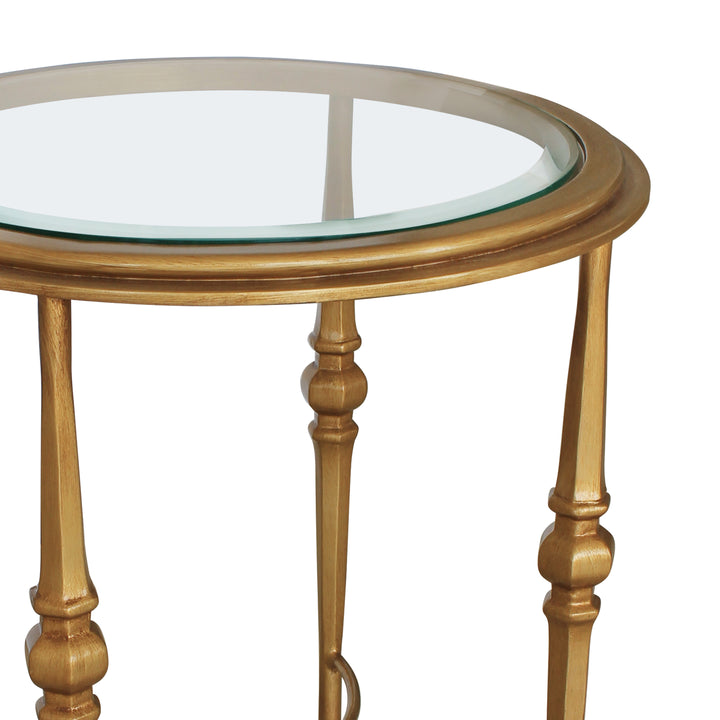 Close up of a classical round side table with glass top painted in antique gold finish