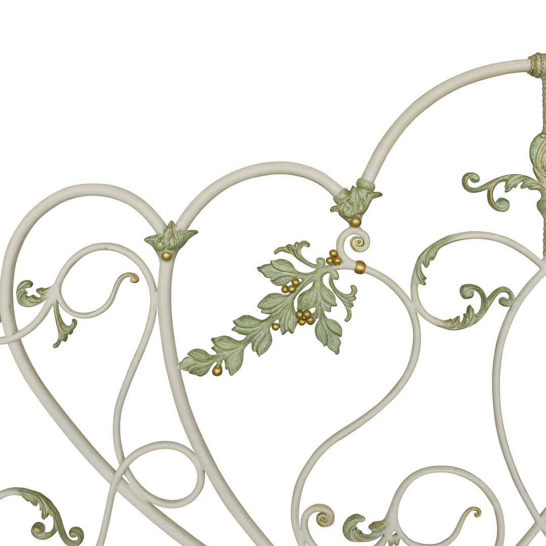 Close up of a nature inspired hand forged iron headboard made up of leaves, in an antique paint finish
