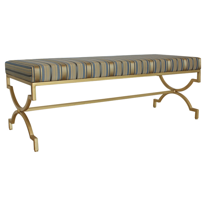 A modern bench with a geometric metal golden base topped with a stripy blue upholstered cushion