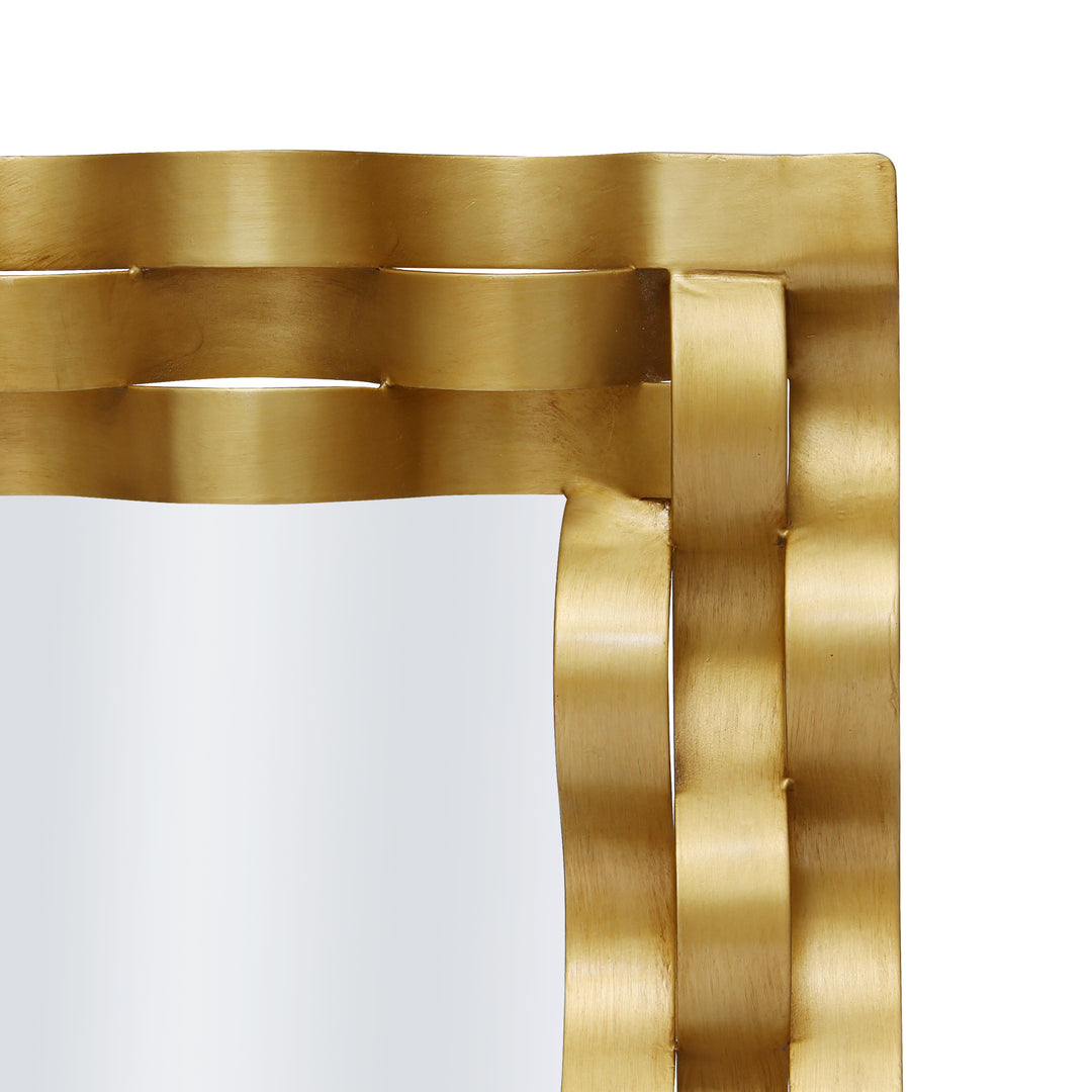 Close up shot of a golden mirror with wavy strips of metal wrapped along its border