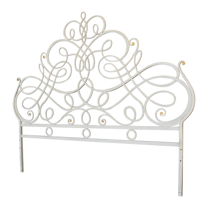 A luxurious wrought iron king sized bed with an organic style painted in an antique white finish