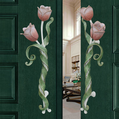 Pair of decorative pull handles inspired by tulips mounted on an open green door