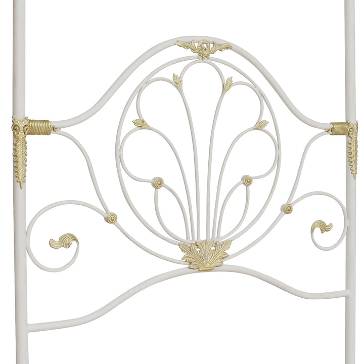 A wrought iron classical headboard for a single canopy bed, painted in a white and gold color