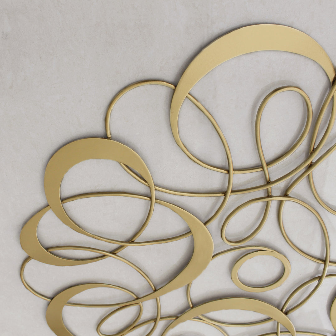Close up of a decorative metallic ceiling medallion with an organic pattern and gold painted finish