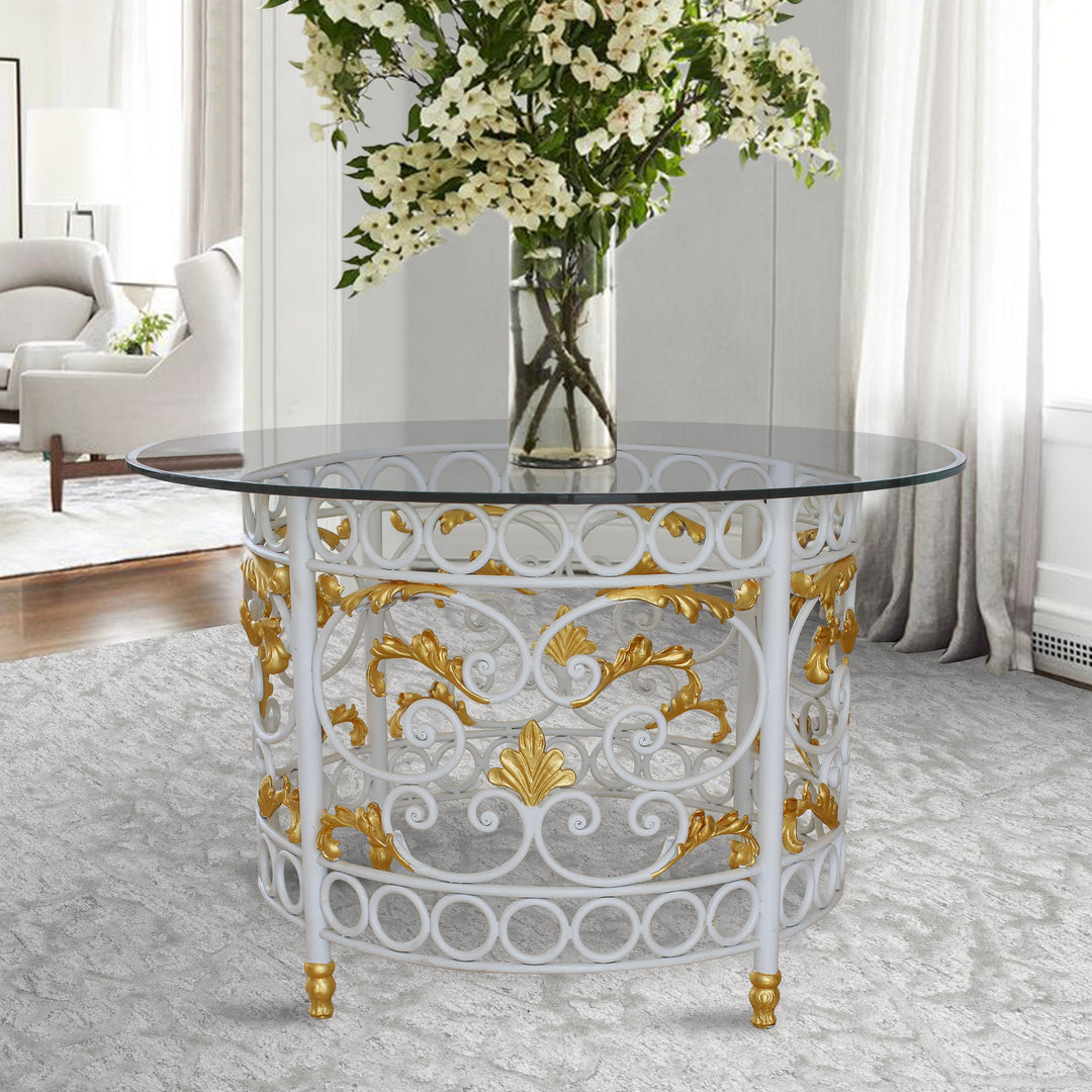 A classical round entrance table with a wrought iron base and a clear glass top in a luxurious entrance hall