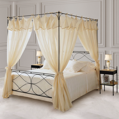 Luxurious black wrought iron king sized bed with an overhead canopy with white beddings