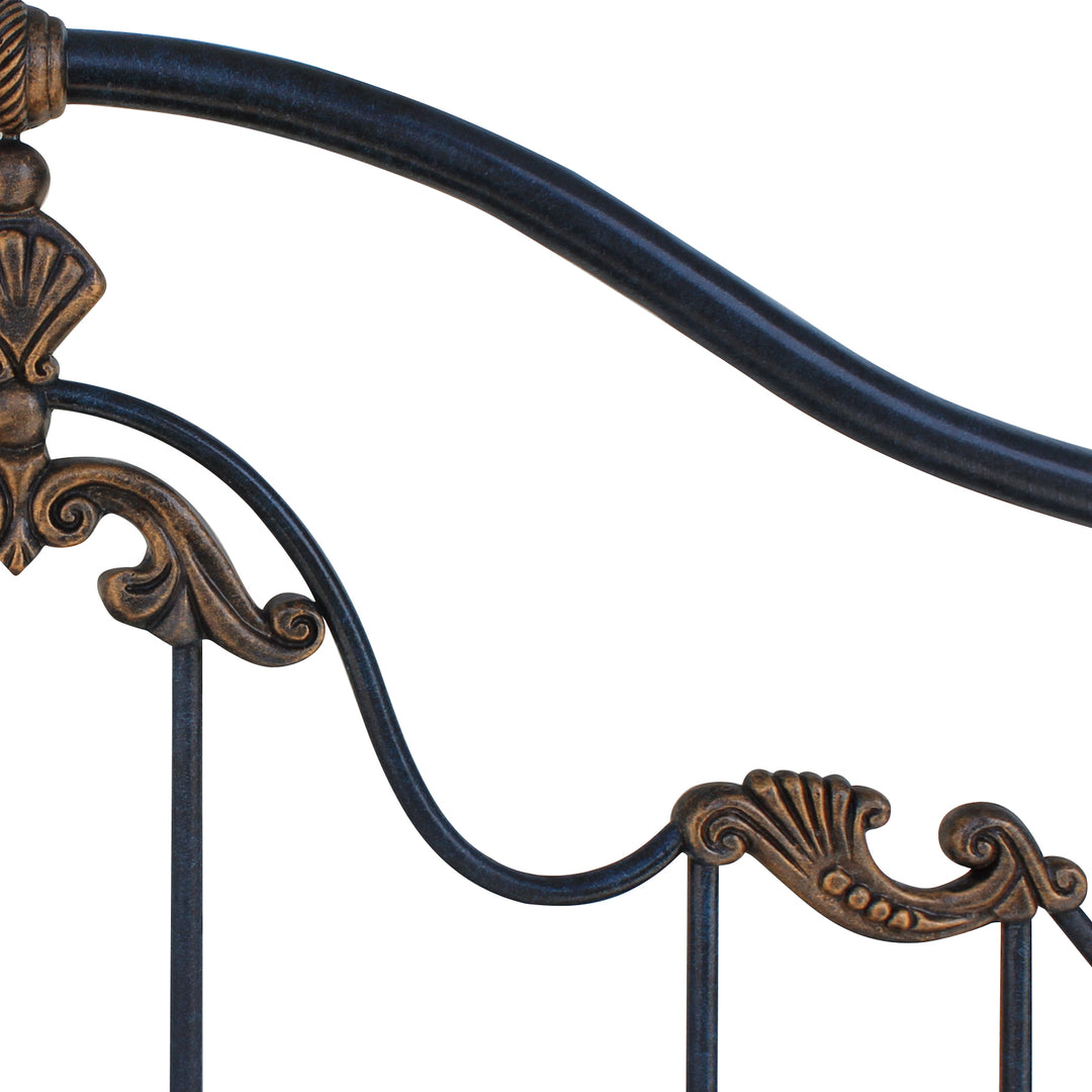 Close up of a classical metal forged headboard with shell motifs painted in an antique deep blue and golden finish