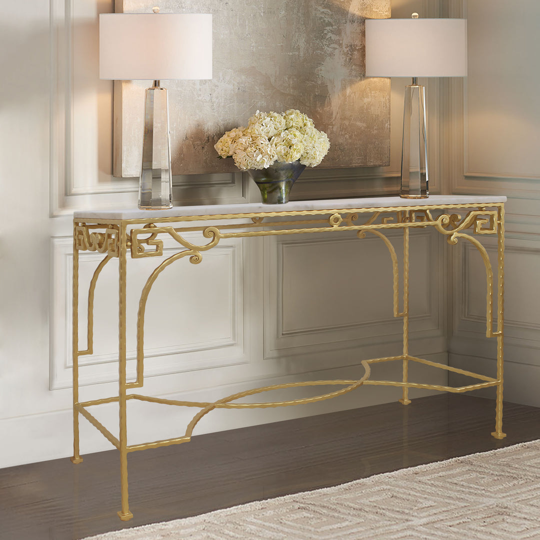 Wrought iron accent console table painted in a bright gold color and topped with a white marble sits in a luxurious living room