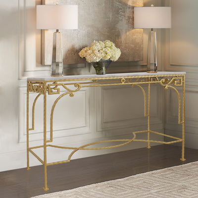 Wrought iron accent console table painted in a bright gold color and topped with a white marble sits in a luxurious living room