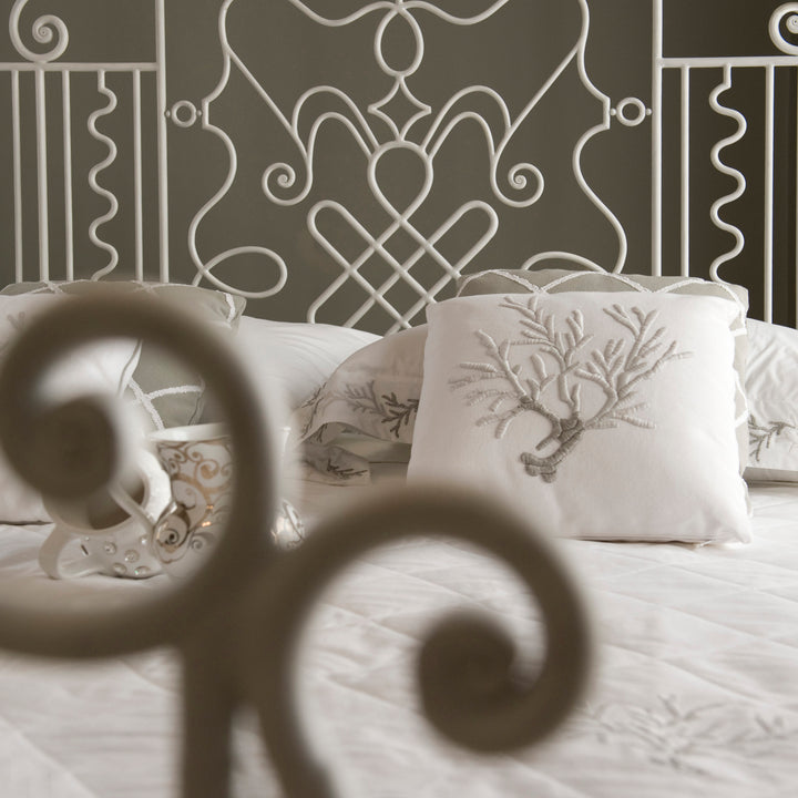 Stylish wrought iron headboard with curves and scrolls in a white painted finish